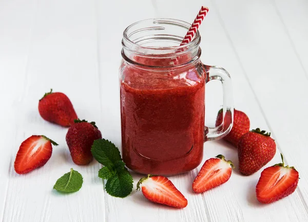 Ahşap bir masa üzerinde çilek güler yüzlü ile jar