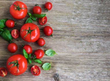 Eski bir ahşap zemin üzerine Yeşil fesleğen ile taze domates