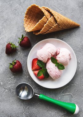 Çilekli dondurma ve waffle koni taş zemin üzerine