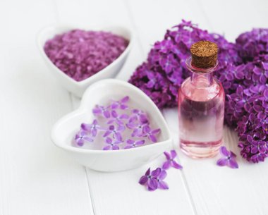 Esans ve deniz tuzu Beyaz ahşap zemin üzerinde eflatun çiçekli