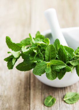 Eski ahşap bir masa üzerinde taze nane ile harç