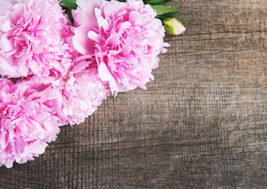 Eski ahşap bir masa pembe şakayık çiçekleri