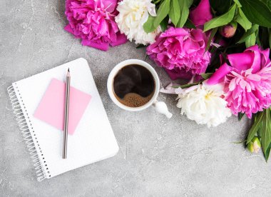 Eski bir taş zemin üzerine peonies ve kahve ile not defteri