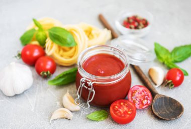 Domates sosu ve malzemeler taş zemin üzerine kavanoz