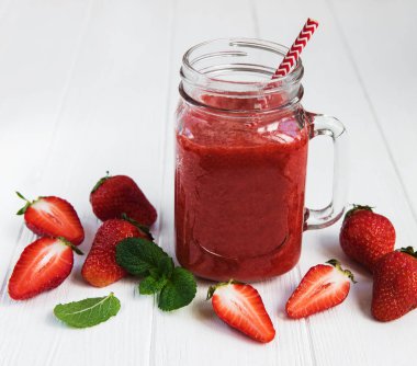 Ahşap bir masa üzerinde çilek güler yüzlü ile jar