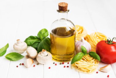 İtalyan gıda katkı maddeleri, zeytinyağı, baharat, makarna ve domates Beyaz ahşap bir masa üzerinde
