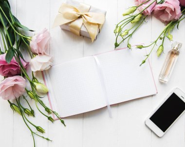 Dekoratif düz dizüstü bilgisayar, telefon ve çiçekler ile kompozisyon yatıyordu