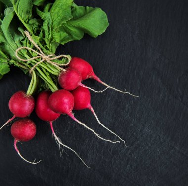 Siyah taş zemin üzerine taze mor turp