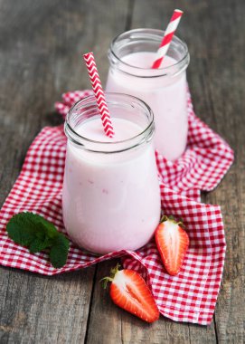 Kavanoz eski ahşap bir masa üzerinde çilekli yoğurt ile