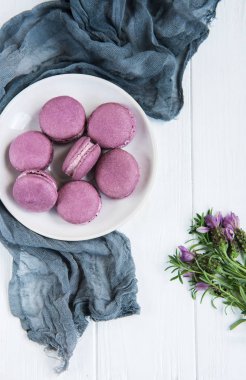 Lavanta macarons Beyaz ahşap bir masa üzerinde plaka