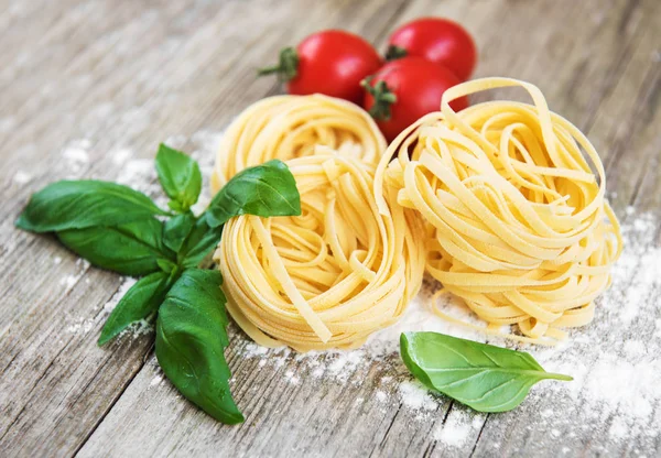 İtalyan makarna bir beyaz tahta masada yeşil Fesleğenli Tagliatelle