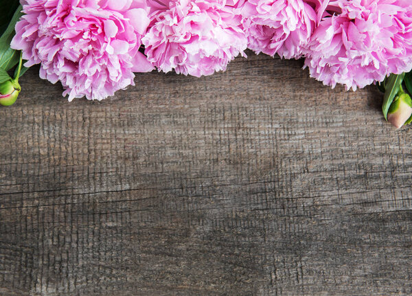 Pink peony flowers on a old  wooden table