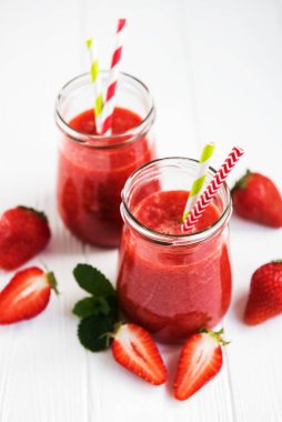 Beyaz ahşap bir masa üzerinde çilek güler yüzlü ile kavanoz