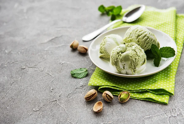 pistachio ice cream and mint with pistachio nuts on a stone background