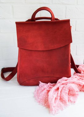 Kırmızı deri sırt çantası ve eşarp beyaz bir tablo