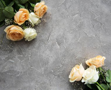 Gri taş zemin üzerine sarı ve beyaz güller