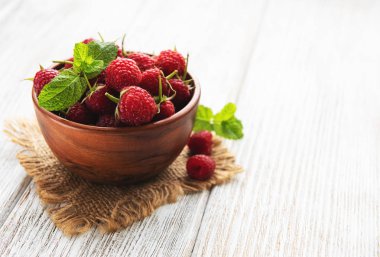 Eski Beyaz ahşap zemin üzerinde taze ahududu ile kase