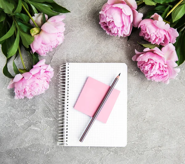note book with peonies on a old stone background