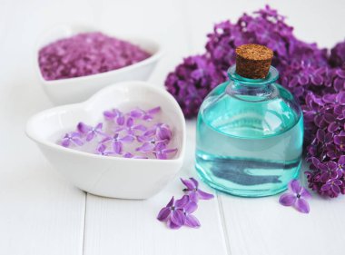 Esans ve deniz tuzu Beyaz ahşap zemin üzerinde eflatun çiçekli