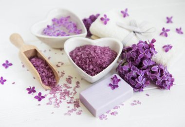 Spa havlu ve beyaz ahşap zemin üzerinde eflatun çiçekler ürünlerle Masaj