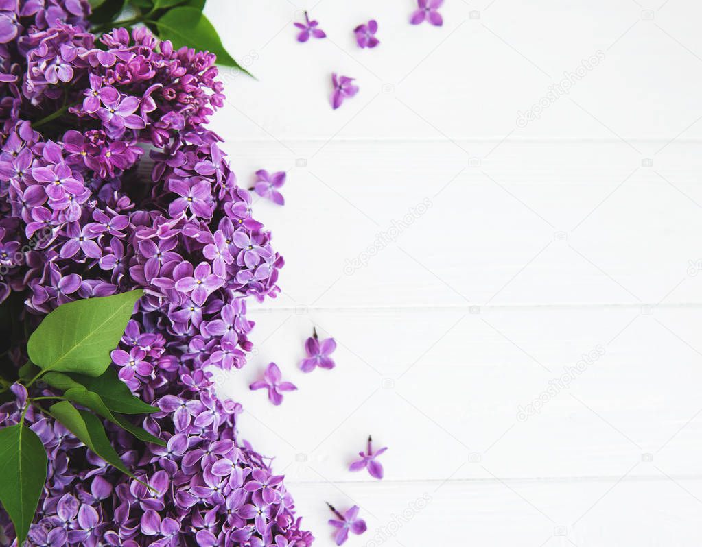 Lilac flowers on a white wooden background