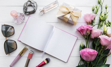 kadın düz temiz defter, kozmetik ve çiçekler ile yatıyordu