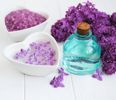 Esans ve deniz tuzu Beyaz ahşap zemin üzerinde eflatun çiçekli