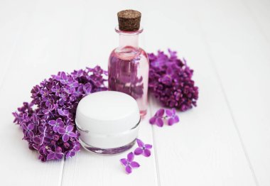 Esans taze leylak çiçeği ve cilt bakım kremi ile şişe