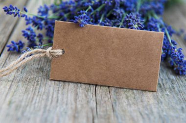 Eski ahşap bir masa üzerinde etiket ve lavanta çiçekleri boş