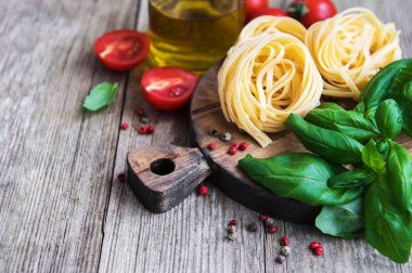 İtalyan gıda maddeleri - makarna, domates, fesleğen ve zeytinyağı eski bir ahşap tablo