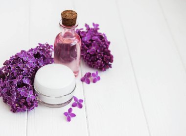 Esans taze leylak çiçeği ve cilt bakım kremi ile şişe