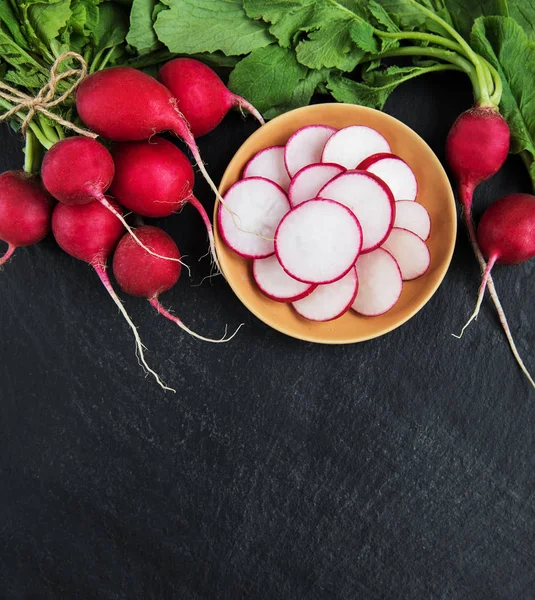 Fresh purple  radish  on the black stone background