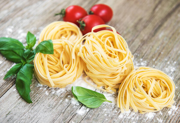 Italian pasta Tagliatelle with green basil on a old  wooden table