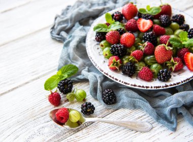 Eski ahşap bir masa üzerinde yaz meyveleri ile plaka