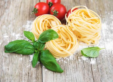 İtalyan makarna bir beyaz tahta masada yeşil Fesleğenli Tagliatelle