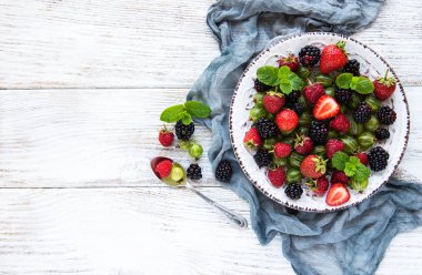 Eski ahşap bir masa üzerinde yaz meyveleri ile plaka