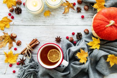 ahşap zemin ile bir fincan çay ve kuru düşen sarı yapraklar üzerinde sonbahar flatlay 