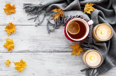 ahşap zemin ile bir fincan çay ve kuru düşen sarı yapraklar üzerinde sonbahar flatlay 