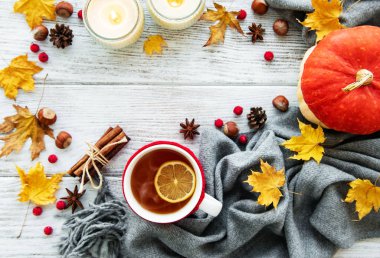 ahşap zemin ile bir fincan çay ve kuru düşen sarı yapraklar üzerinde sonbahar flatlay 