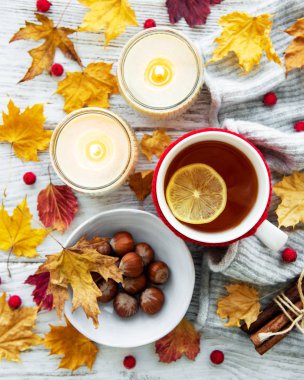 ahşap zemin ile bir fincan çay ve kuru düşen sarı yapraklar üzerinde sonbahar flatlay 