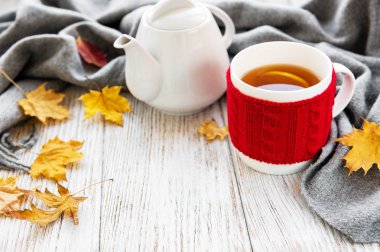  fincan çay ve bir ahşap zemin üzerine düşen kuru sarı yapraklar