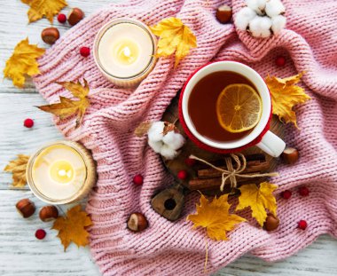 ahşap zemin ile bir fincan çay ve kuru düşen sarı yapraklar üzerinde sonbahar flatlay 