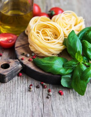 İtalyan gıda maddeleri - makarna, domates, fesleğen ve zeytinyağı eski bir ahşap tablo