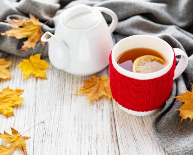  fincan çay ve bir ahşap zemin üzerine düşen kuru sarı yapraklar