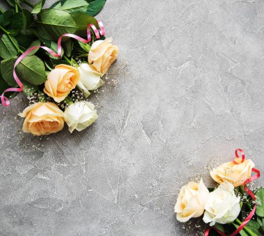 Gri taş zemin üzerine sarı ve beyaz güller