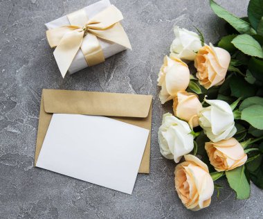 Beyaz güller ve beton zemin üzerine tebrik kartı