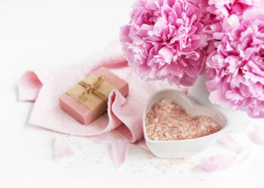 kalıp el yapımı sabun, yumuşak havlu ve bir beyaz tahta masaya peony çiçek