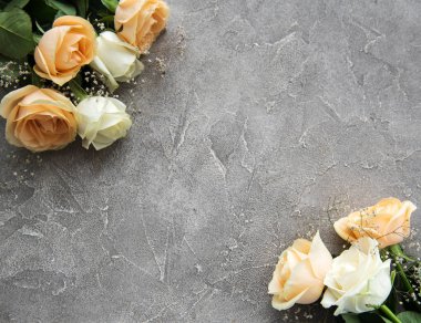 Gri taş zemin üzerine sarı ve beyaz güller