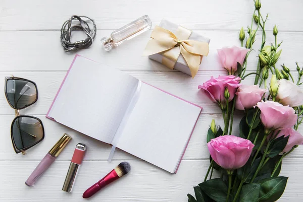kadın düz temiz defter, kozmetik ve çiçekler ile yatıyordu