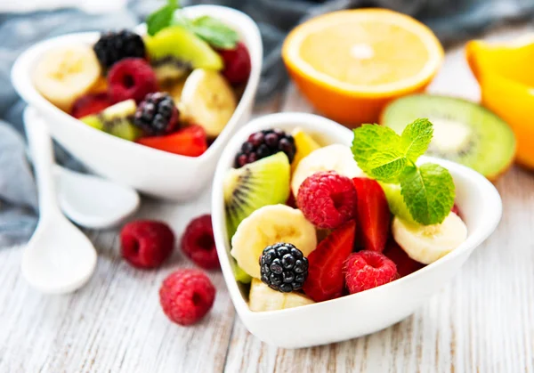 Bowls with fruits salad on a old wooden table